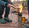 person grilling food over campstove