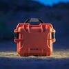 Nanuk 908 case, red, on ground at night with spotlight on it
